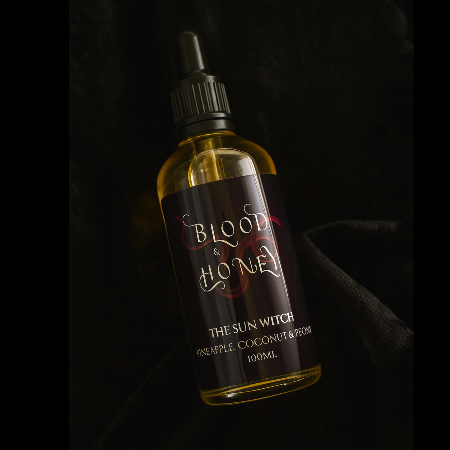 Bottle of 'Blood & Honey' The Sun witch body oil, with a dark label on a black background